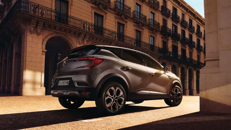 Vozilo Renault Captur prikazano straga, parkirano ispred povijesne zgrade u gradu.