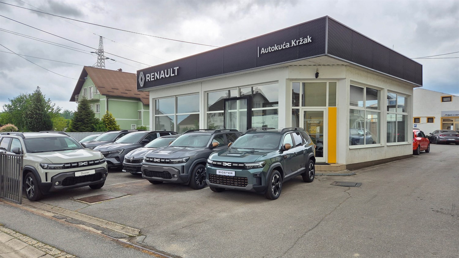 Vanjski pogled na Renault Autokuću Kržak, s parkiranim vozilima ispred zgrade.








