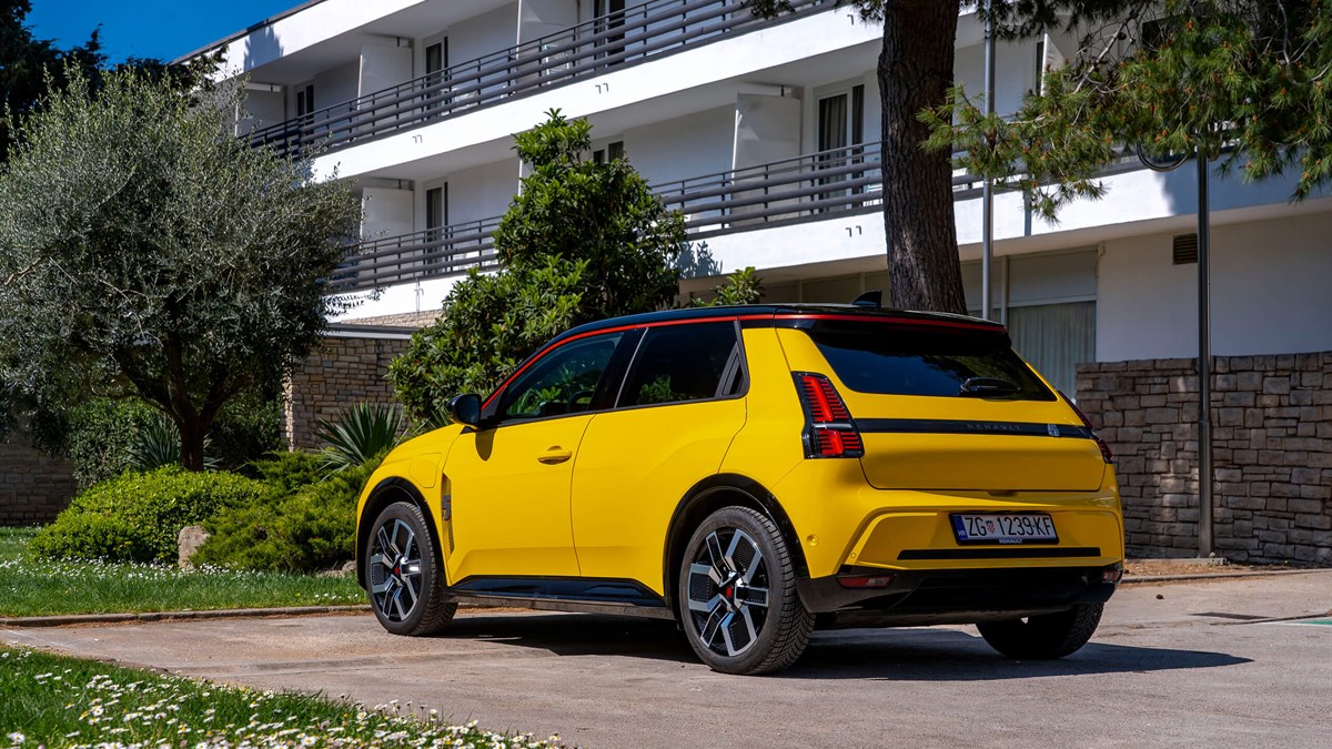 Žuti Renault 5 E-Tech electric parkiran ispred zgrade.