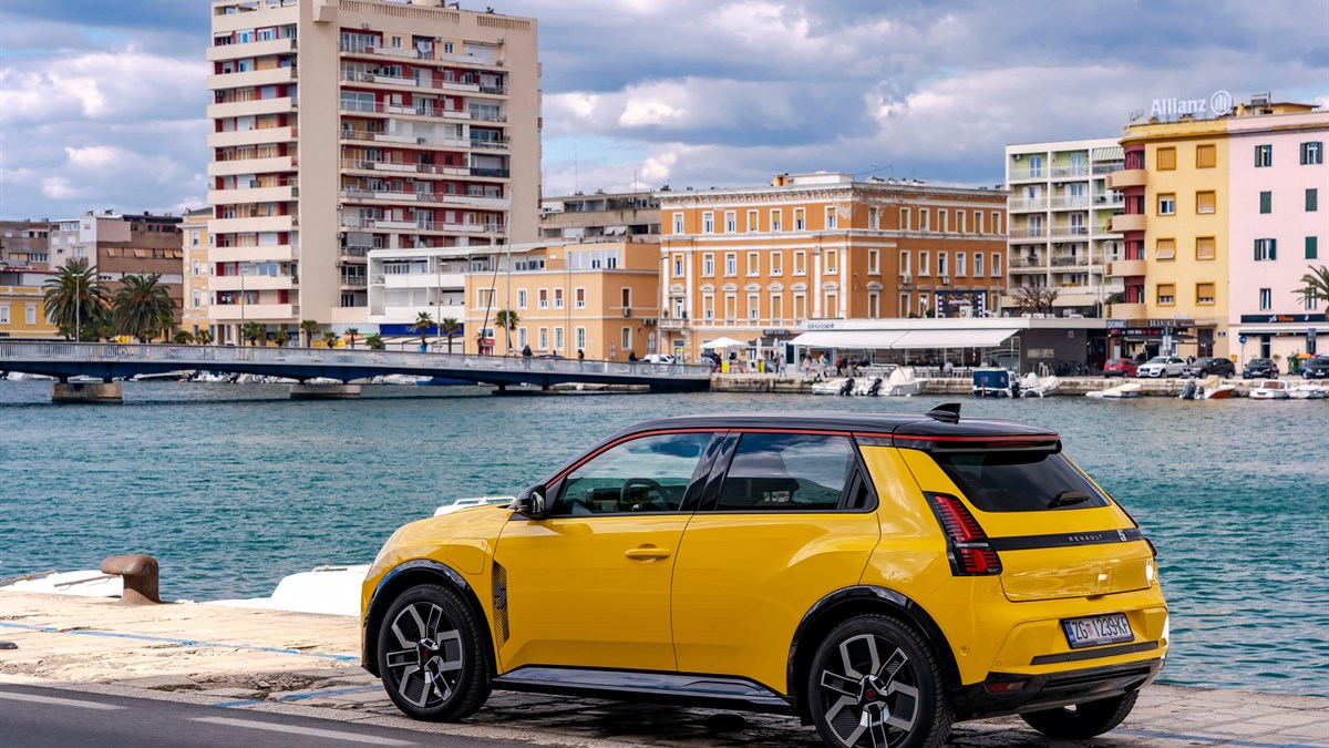 Žuti Renault 5 E-Tech electric parkiran ispred mora.
