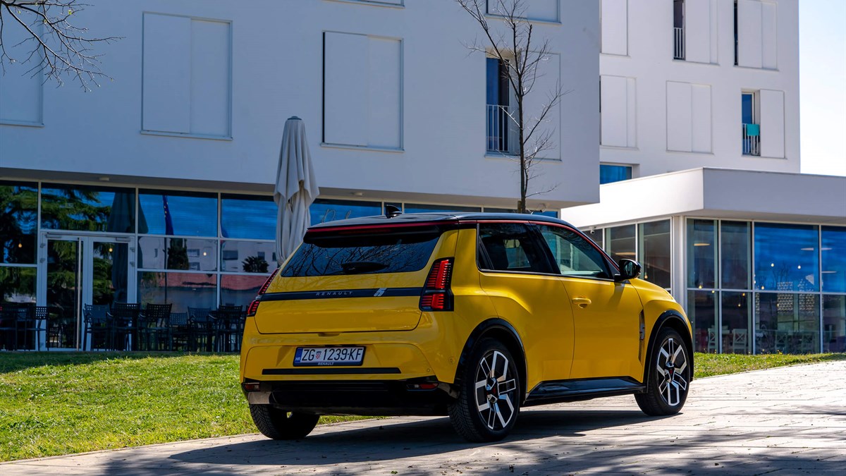 Žuti Renault 5 E-Tech electric parkiran ispred zgrade.