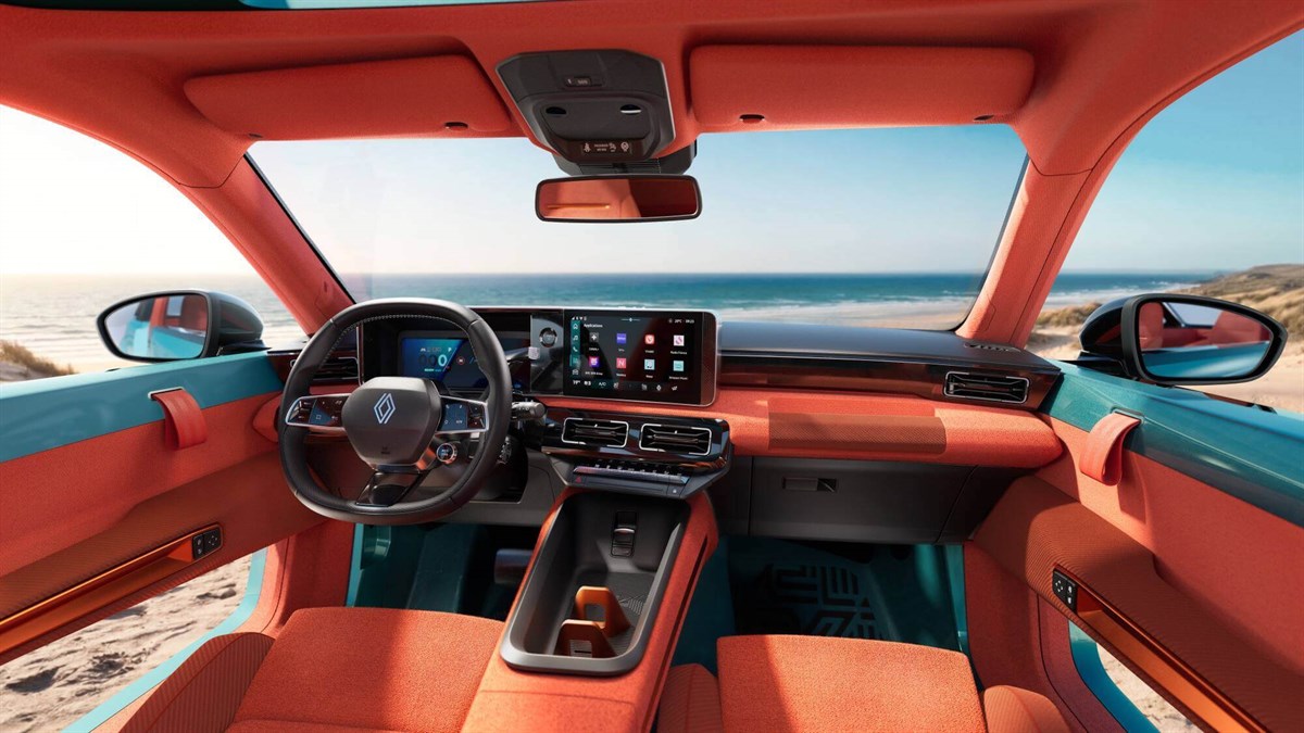 Interijer vozila Renault s narančastim detaljima, digitalnim zaslonima i pogledom na more kroz panoramski otvor krova.