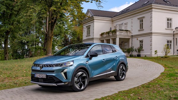 Vozilo Renault Symbioz full hybrid E-Tech parkirano ispred klasične bijele vile u zelenom okruženju.

