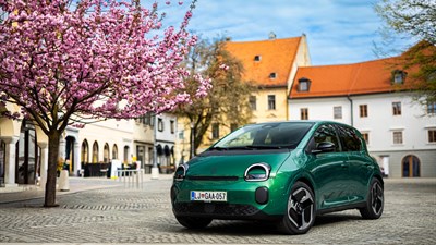 Vozilo Twingo E-Tech electric parkirano uz rijeku s pogledom na gradske kuće i most u pozadini.