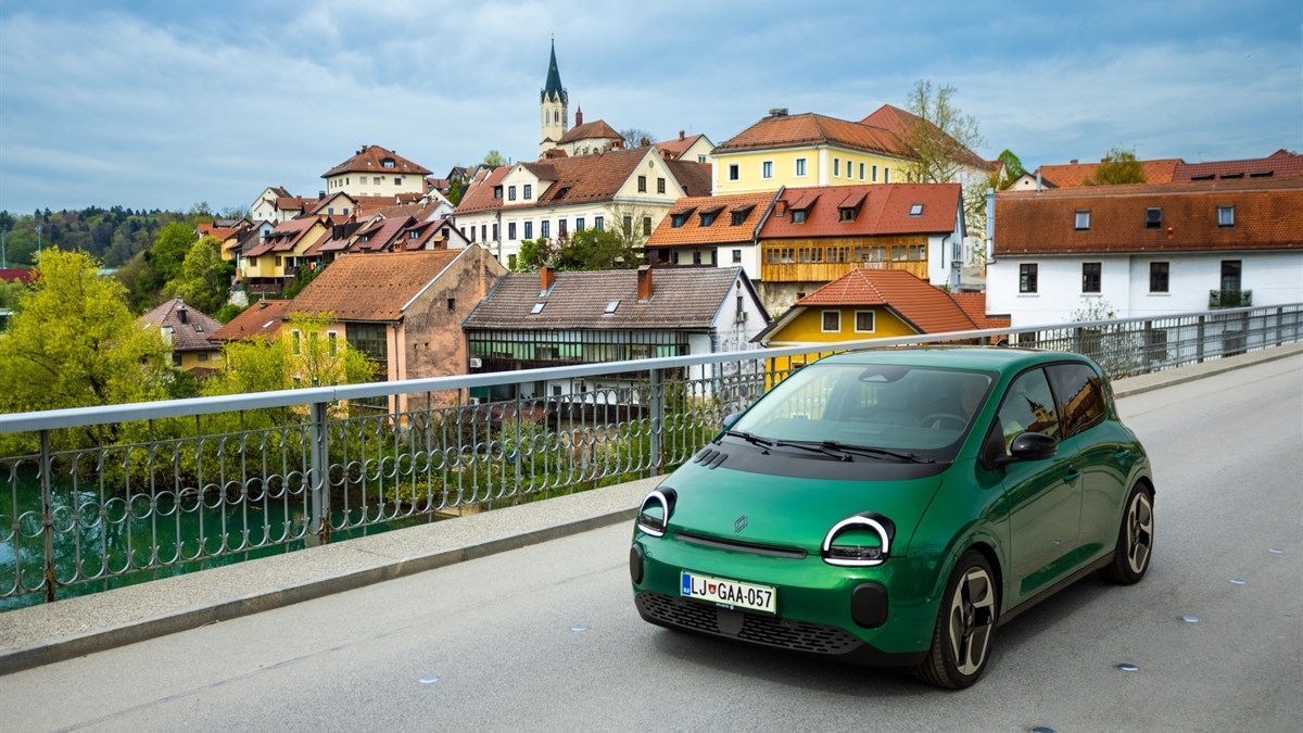 vozilo Twingo E-Tech electric parkirano uz rijeku s pogledom na gradske kuće i most u pozadini
