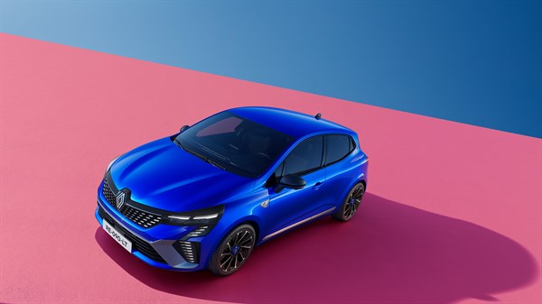 Pogled odozgo na plavo vozilo Renault u tročetvrtinskom prednjem prikazu, parkirano na ružičastoj podlozi s plavom pozadinom, s crnim naplatcima i istaknutim prednjim svjetlima.