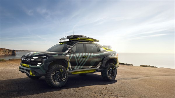 Bočni prikaz tamnog vozila Renault s krovnim nosačima i žutim detaljima, parkiranog na otvorenom prostoru uz obalu mora pod vedrim nebom.