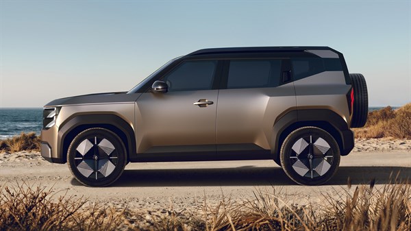 Bočni pogled na vozilo Renault Bridger Concept parkirano uz obalu mora s minimalističkim dizajnom, velikim kotačima i rezervnim kotačem na stražnjem dijelu vozila