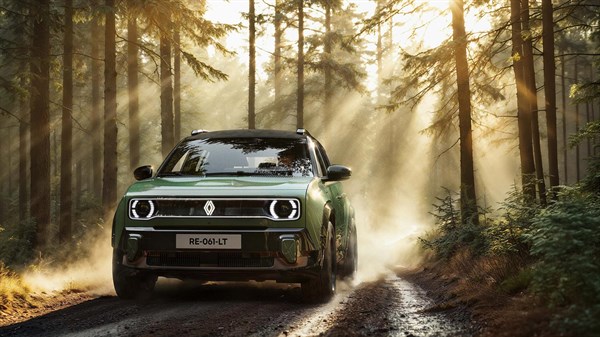 Renault 4 E-Tech electric u zelenoj boji vozi šumskom cestom, dok sunčeve zrake prolaze kroz krošnje drveća.