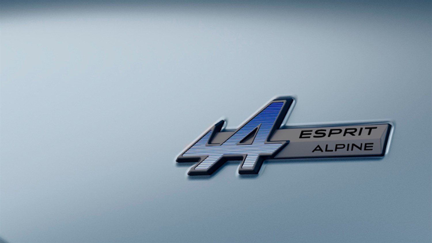 Amblem “A4 Esprit Alpine” u srebrno-plavoj izvedbi na svijetloj podlozi.