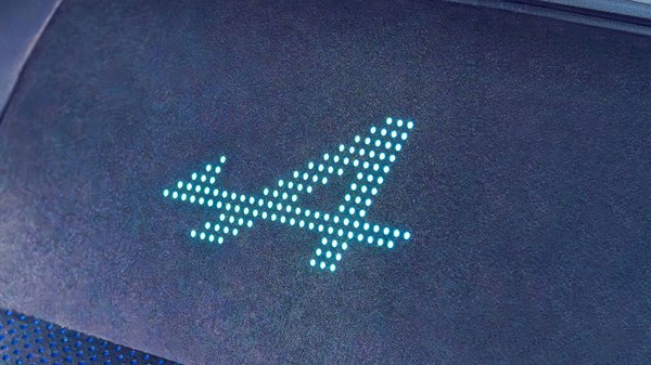 Osvijetljeni logotip Alpine projiciran na podu vozila.