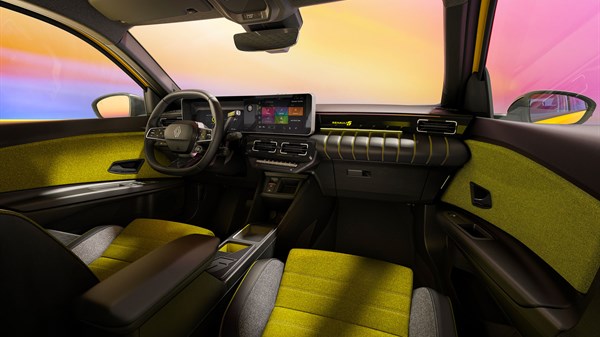 Unutrašnjost vozila Renault 5 E-Tech electric s prikazom upravljača, digitalnog zaslona i presvlaka sjedala u žutoj i crnoj boji, na pozadini zalaska sunca.