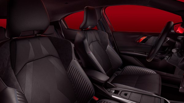 Unutrašnjost vozila Renault Clio s prikazom prednjih sjedala u crnoj boji i upravljača, uz crveno ambijentalno osvjetljenje u pozadini.