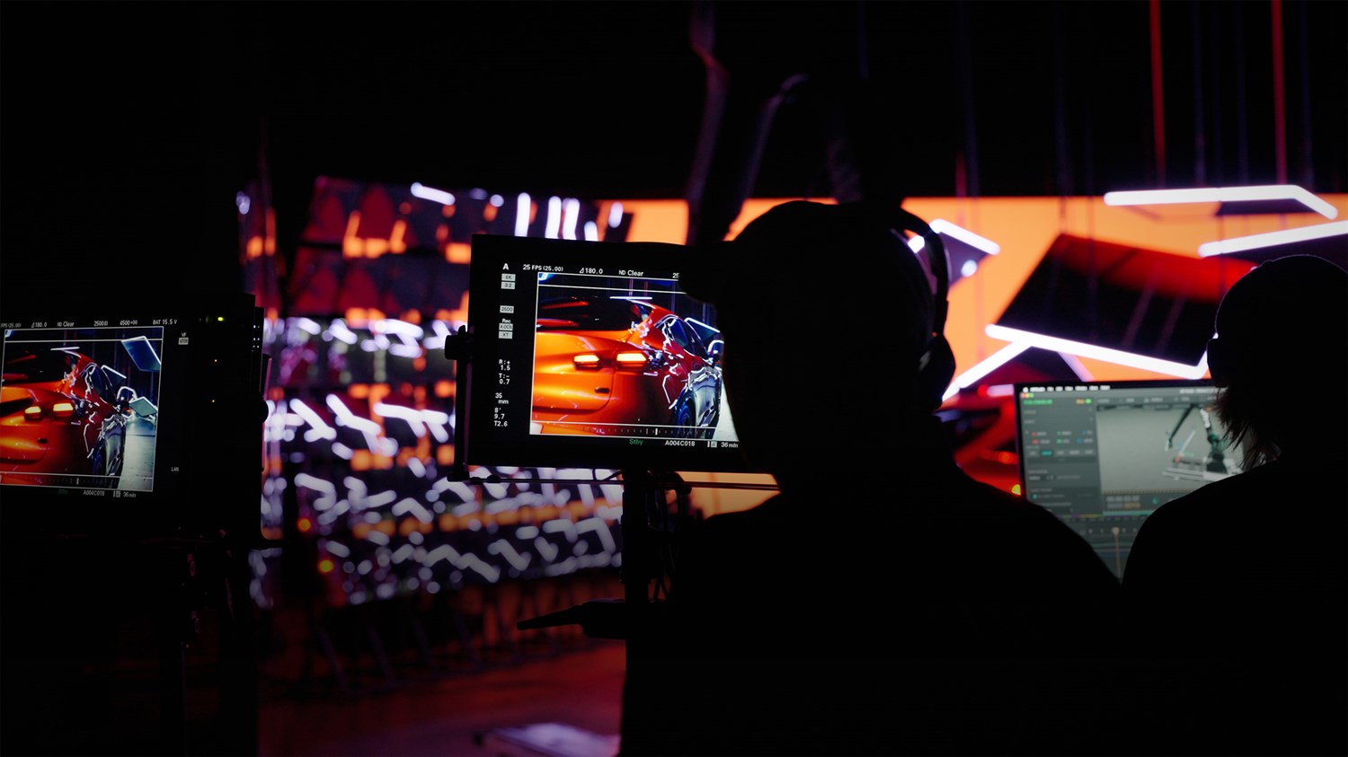 Snimanje reklame za vozilo Renault u studiju, s kamerama i ekranima koji prikazuju stražnji dio vozila pod jakim studijskim svjetlima.