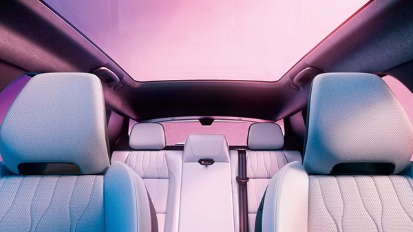 Unutrašnjost vozila Renault s prikazom stražnjih sjedala i panoramskog staklenog krova s ružičasto-ljubičastim osvjetljenjem.