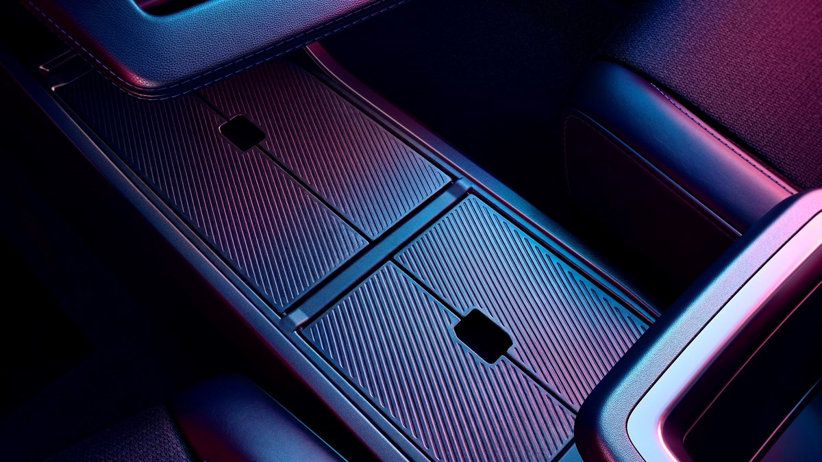 Detalj interijera plavog vozila Renault Megane E-Tech electric s podnim oblogama i središnjom konzolom osvijetljenima plavim i ružičastim svjetlom.