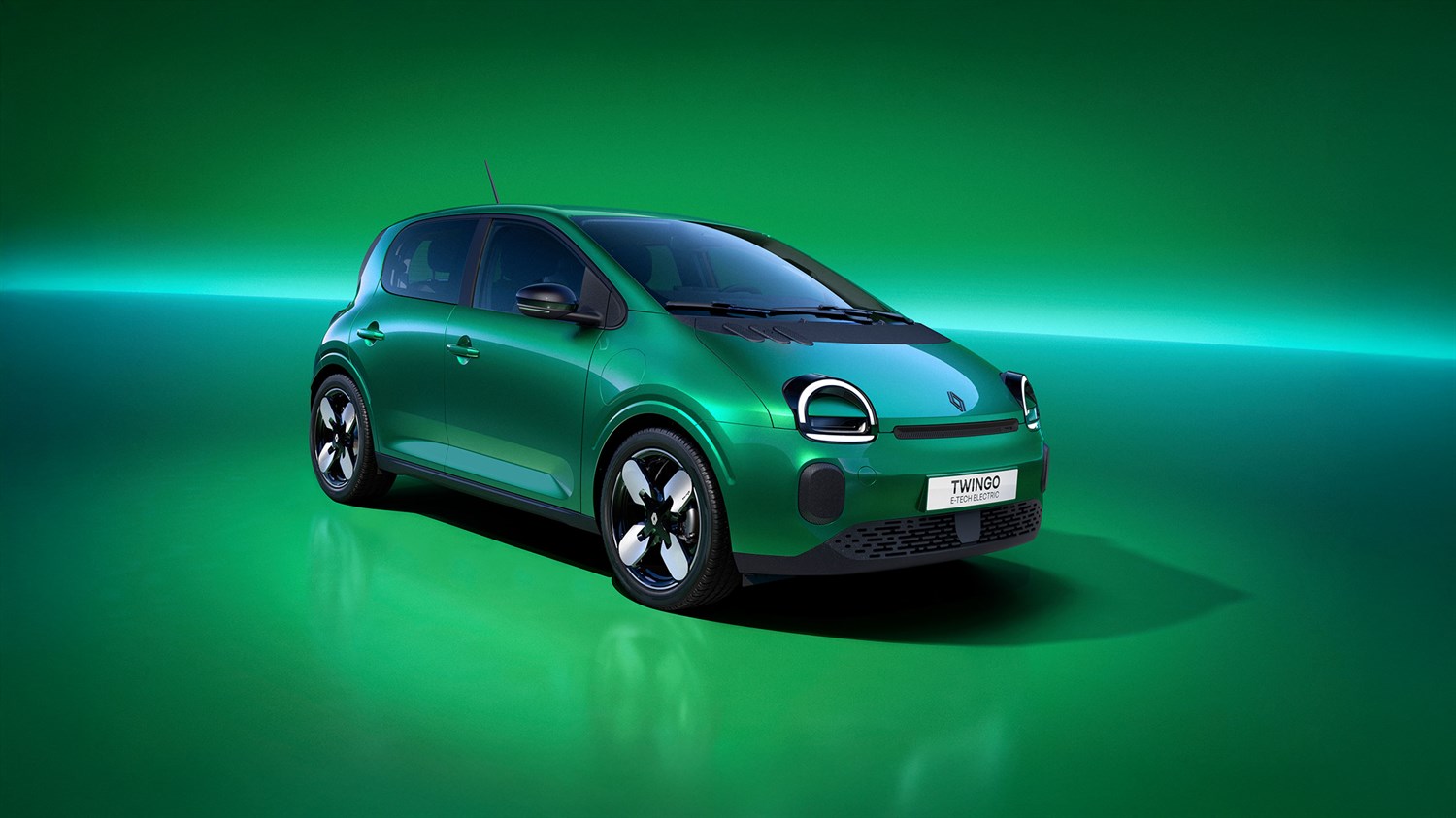 Prednji bočni pogled na vozilo Renault Twingo E-Tech electric u zelenoj boji, s istaknutim dizajnom prednjih svjetala i naplataka, prikazano u studijskom okruženju.