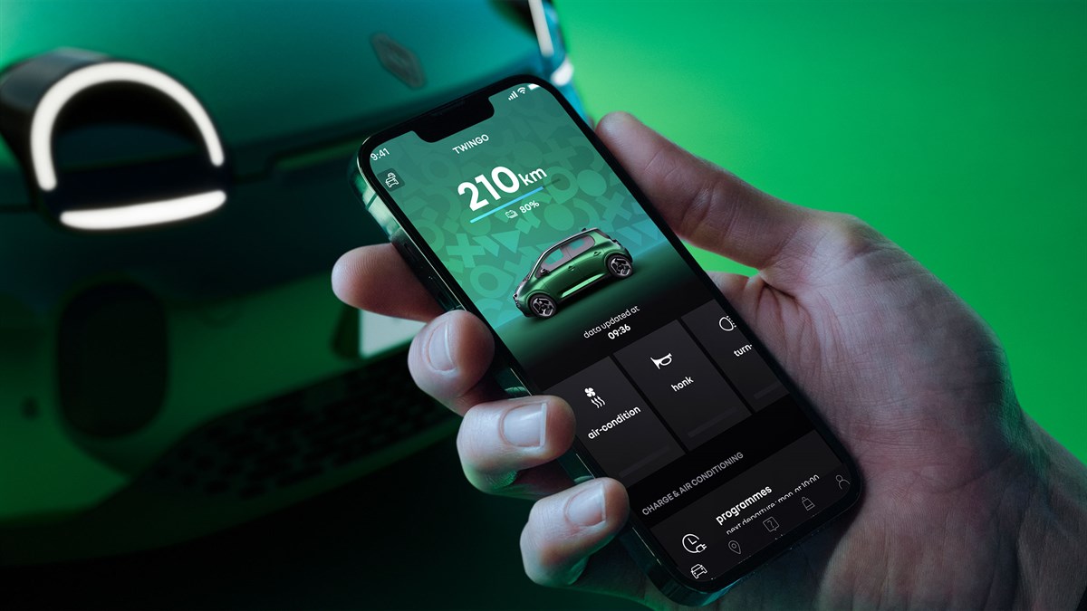 Detalj pametnog telefona u ruci s otvorenom aplikacijom My Renault, prikaz dosega vozila Renault Twingo E-Tech electric, stanja baterije i daljinskih funkcija upravljanja.