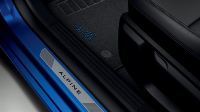 Detalj tekstilnih tepiha s oznakom Alpine i dijela vrata vozila Clio full hybrid E-Tech.
