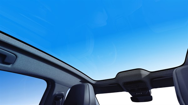 Pogled iz unutrašnjosti vozila Renault Rafale prema panoramskom krovu u potpuno prozirnom stanju, s jasnim pogledom na plavo nebo.







