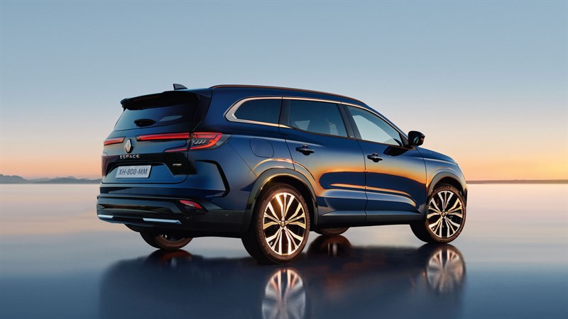 Plavo vozilo Espace full hybrid E-Tech parkirano na glatkoj površini s odrazom, u pozadini zalazak sunca nad vodom.