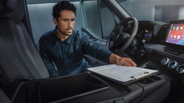 Vozač koristi preklopivi stol u kabini vozila Renault Master kao mobilni ured