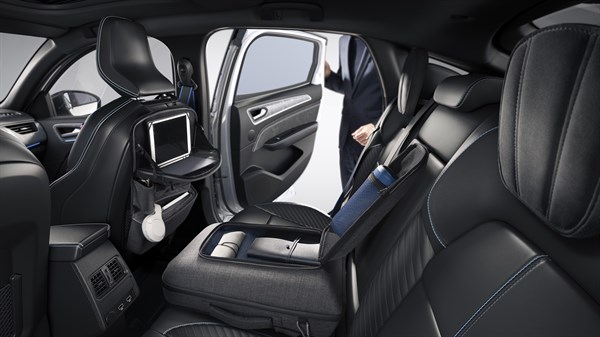 
Stražnji dio unutrašnjosti vozila Megane Conquest full hybrid E-Tech s otvorenim vratima, prikaz tableta i praktičnih dodataka za putnike.

