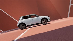 Vozilo Renault 5 E-Tech electric u Roland-Garros verziji parkirano uz moderan arhitektonski zid.