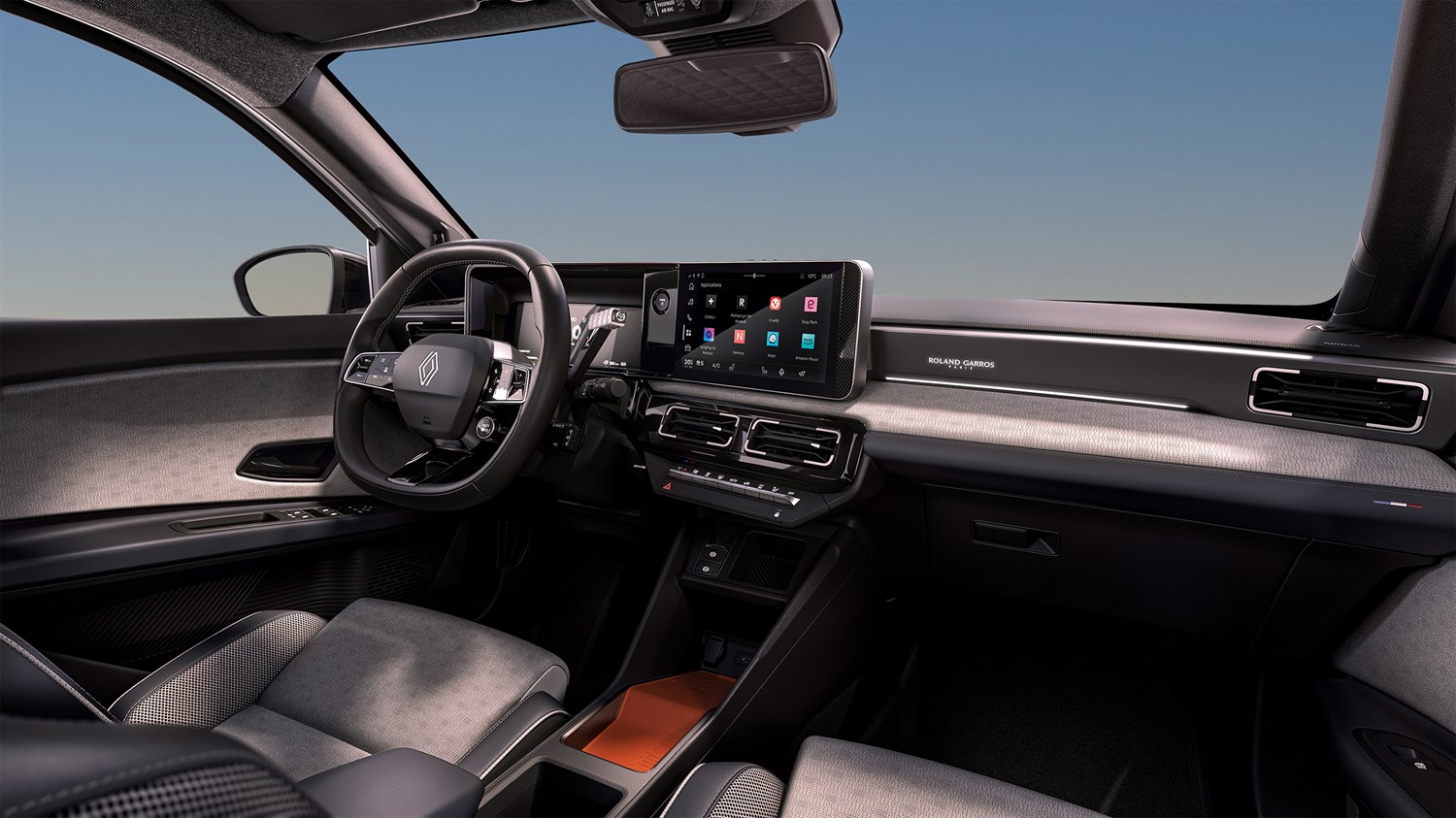 Unutrašnjost vozila Renault 5 Roland-Garros s ekskluzivnim presvlakama i plavim detaljima, digitalnim kokpitom i istaknutim Roland-Garros logotipom ispod putničkog zaslona
