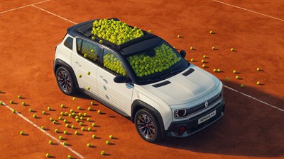 Vozilo Renault 5 E-Tech electric prekriveno teniskim lopticama parkirano na terenu za tenis