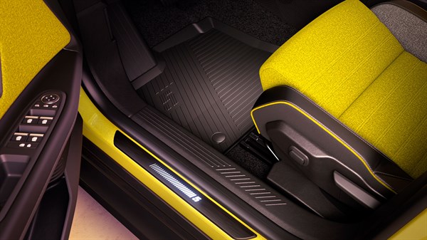 Unutrašnjost vozila Renault 5 s prikazom osvijetljenog praga vrata s logotipom broja 5 i sportskim žutim sjedalima