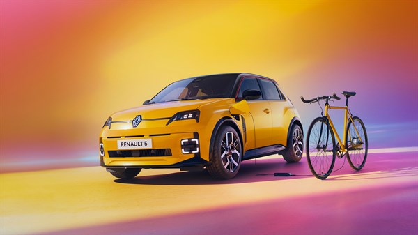 Vozilo Renault 5 parkirano uz žuti bicikl, ilustracija korištenja V2L tehnologije za punjenje vanjskih uređaja iz baterije vozila