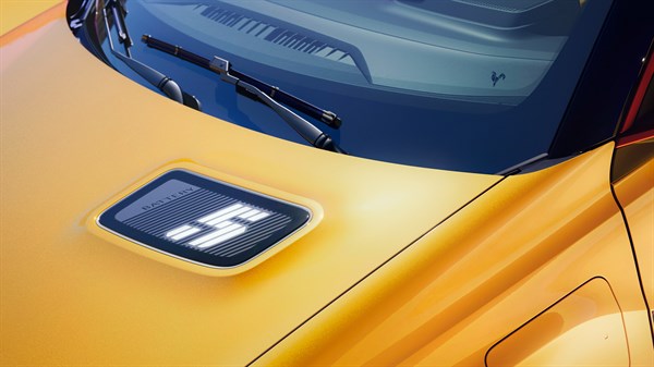 Detalj prednjeg dijela Renault 5 s istaknutim logotipom na haubi, simbolizira performanse i domet do 410 km.