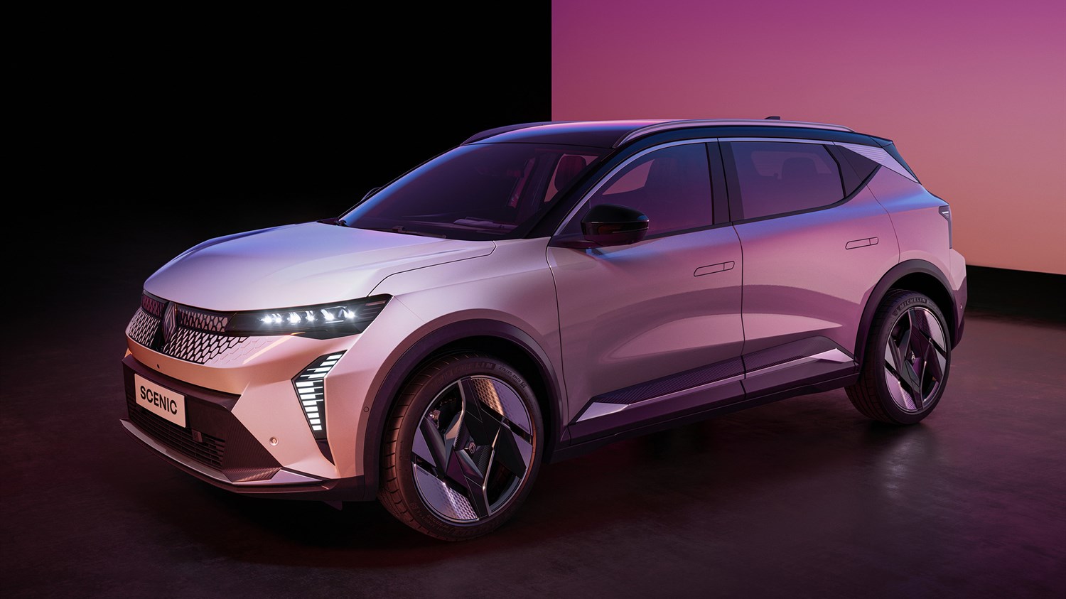 Bijelo vozilo Renault Scenic, parkiran u studijskom prostoru.