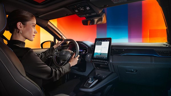 Vozačica u vozilu Captur full hybrid E-Tech koristi središnji multimedijski ekran s aplikacijama.