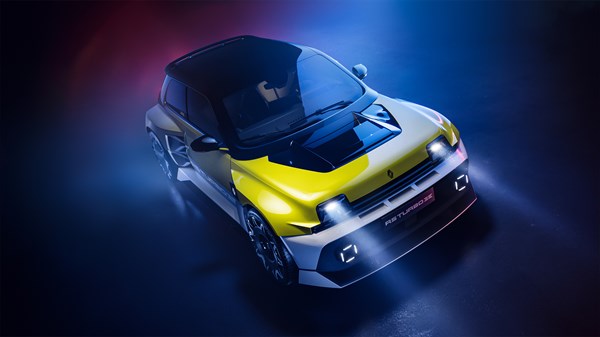 Renault 5 Turbo 3E prikazan u dinamičnom svjetlosnom okruženju, s naglaskom na prednji dio vozila u žuto-crnoj boji.

