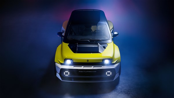 Prednji pogled na vozilo R5 Turbo 3E E-Tech electric s dinamičnim svjetlom i tamnom pozadinom, naglašeni žuti i crni detalji.

