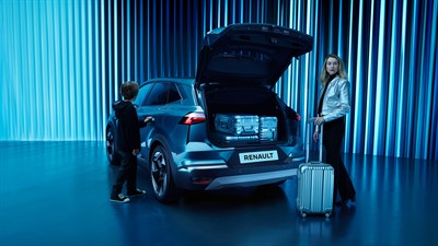 Vozilo Renault Symbioz full hybrid E-Tech s otvorenim prtljažnikom, uz kojeg stoje dječak i žena s koferom u modernom ambijentu plavih svjetlosnih linija.