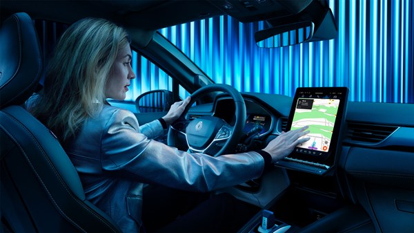Žena u vozilu Renault Symbioz full hybrid E-Tech koristi središnji zaslon za navigaciju.