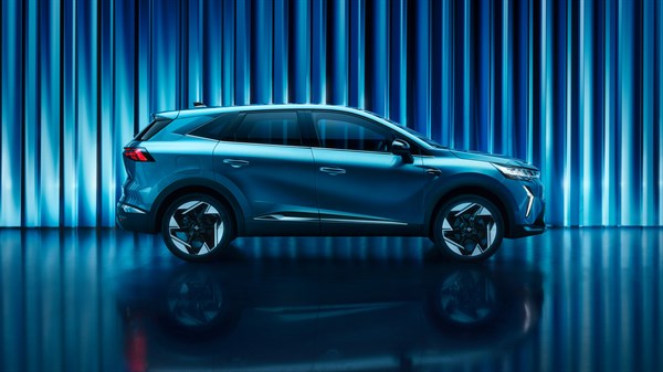 Bočni pogled na vozilo Renault Symbioz full hybrid E-Tech u studiju s plavim osvjetljenjem i refleksijom na podu.

