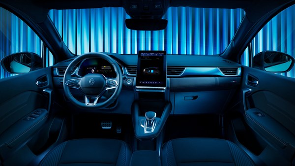 Pogled iz stražnjih sjedala na unutrašnjost vozila Renault Symbioz full hybrid E-Tech s istaknutim digitalnim zaslonima i plavim ambijentalnim osvjetljenjem.


