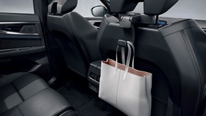 Naslon za glavu u vozilu Renault Austral full hybrid E-Tech s kukom na koju je obješena torba.

