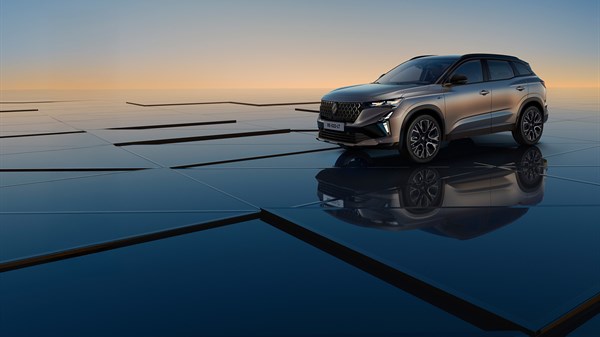 Vozilo Renault Austral full hybrid E-Tech parkirano na reflektirajućoj površini uz zalazak sunca u pozadini