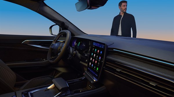 Pogled iz unutrašnjosti vozila Renault Austral full hybrid E-Tech prema muškarcu ispred vozila, uz prikaz središnjeg zaslona.

