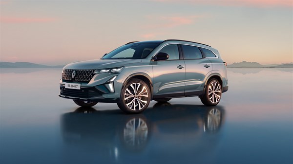 Renault Espace full hybrid E-Tech na cesti pri zalasku sunca

