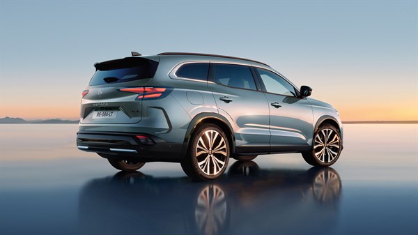 Stražnji dio vozila Espace full hybrid E-Tech na reflektirajućoj površini s pogledom na zalazak.