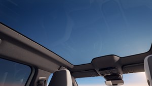 Pogled iz unutrašnjosti vozila Renault Espace full hybrid E-Tech prema zatamnjenom panoramskom krovu Solarbay®.

