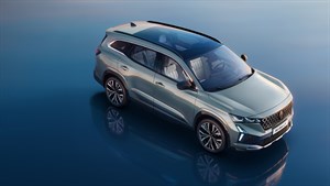 Vozilo Espace full hybrid E-Tech u svijetlo sivoj boji parkirano na reflektirajućoj površini, prikazano iz gornjeg kuta s otvorenim panoramskim krovom.