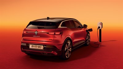 Vozilo Megane E-Tech electric priključeno na punionicu u narančastom ambijentu.

