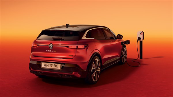 Vozilo Megane E-Tech electric spojeno na punionicu u pozadini narančaste boje.

